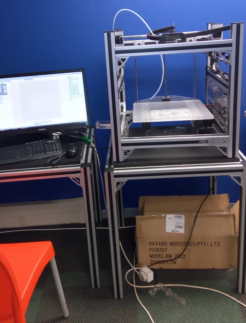 Impressora 3D de câmara fechada vista de perfil sobre bancada